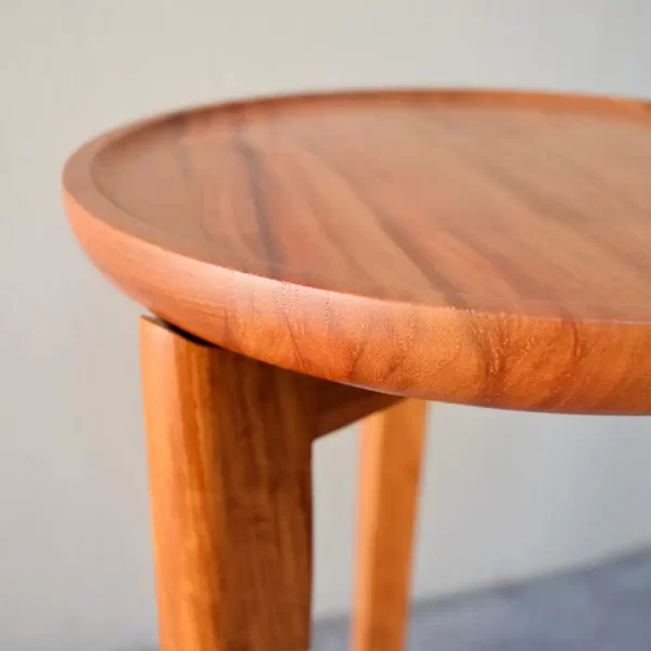 The Tully Side Table designed and crafted by Buywood Furniture featuers rounded tapered legs with a cross base supporting the dished-out round top.