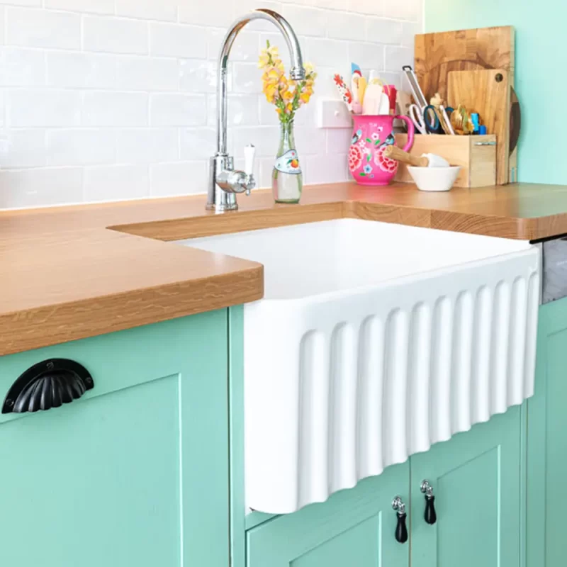 This farmhouse timber kitchen is ergonomically designed for convenience and family living. Fluted sink and solid wood doors painted in a very trendy pastel mint green .