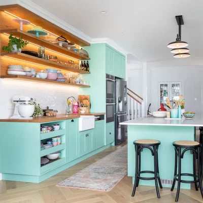 Ergonomically designed for convenience and family living, this unique farmhouse – chic kitchen features solid wood doors painted in a very trendy pastel mint green.