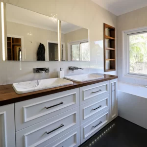 Custom timber bathroom vanity with double basins, mirror cabinets designed & installed by Buywood Furniture.