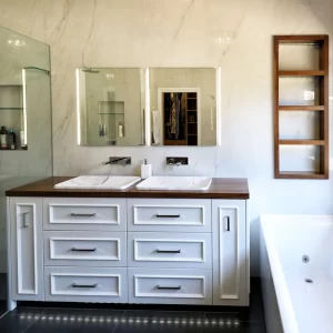 Custom timber bathroom vanity with double basins, mirror cabinets and shelving designed & installed by Buywood Furniture.