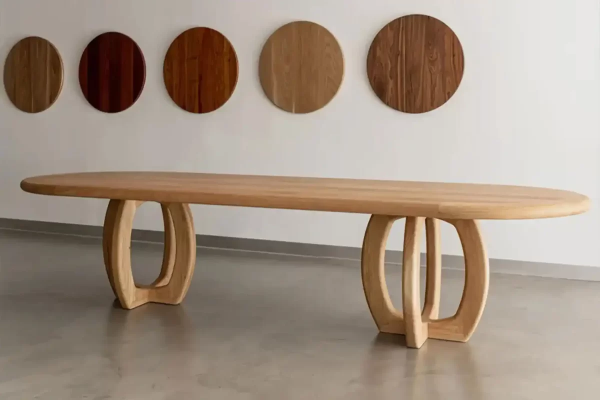 Banksia Long table by Buywood Furniture, is a bespoke solid timber dining table featuring a curved jigsaw mitre joint base and framed rounded top